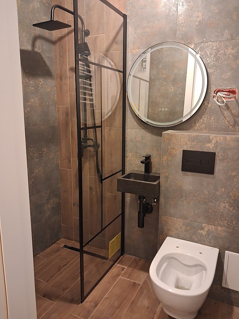 Realizacja Tyrbud, łazienka z drewnem i prysznicem walk-in